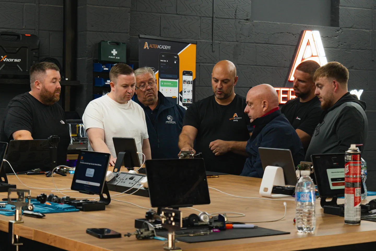 The class at the bench on day 1, trainers and students round the tools