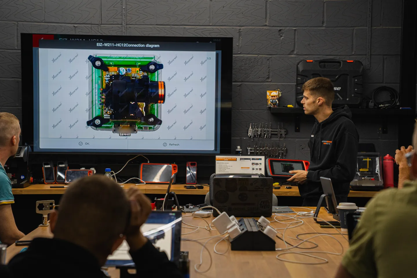 A trainer explains a connection diagram on the big screen