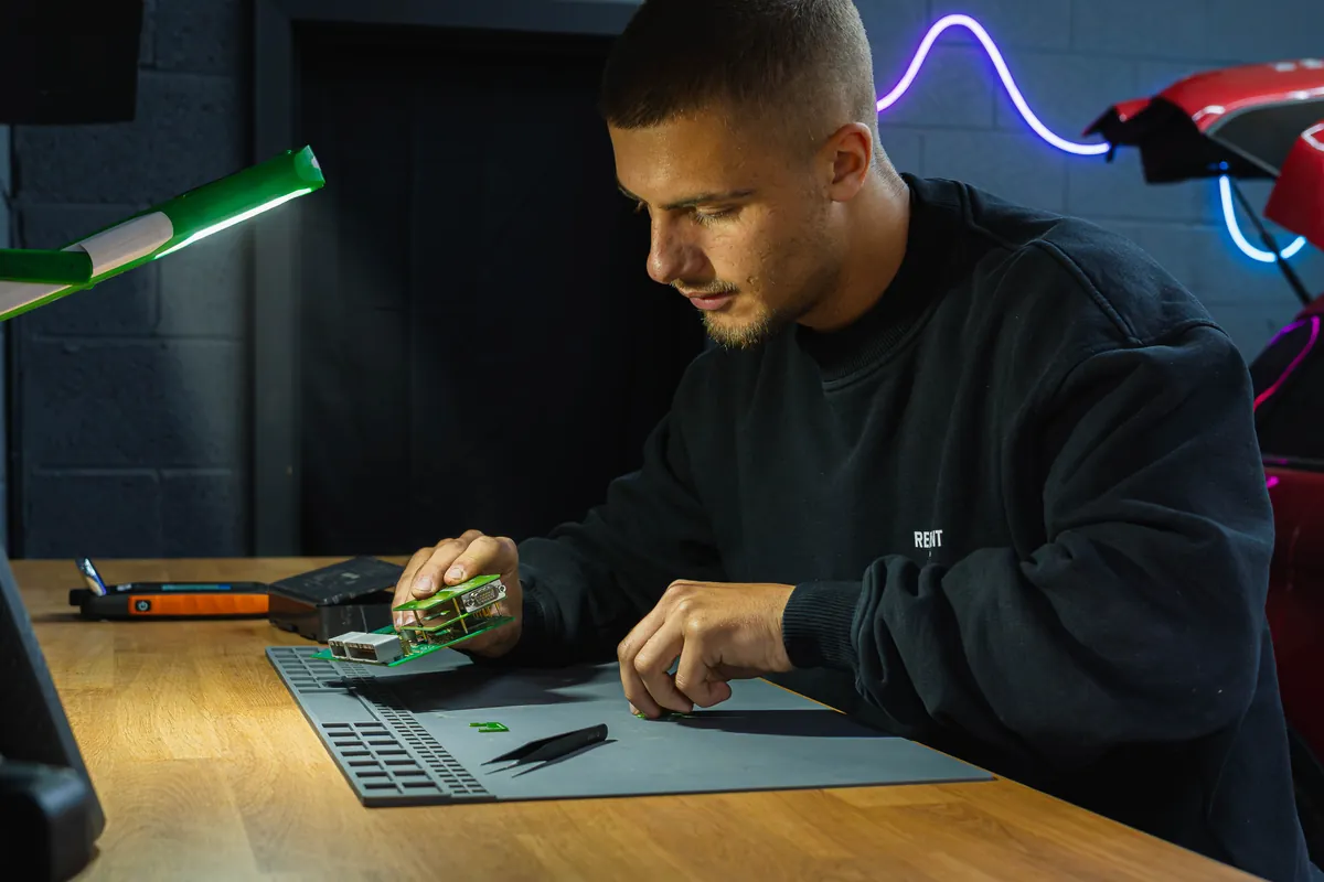 A student works on a circuit board himself at the bench