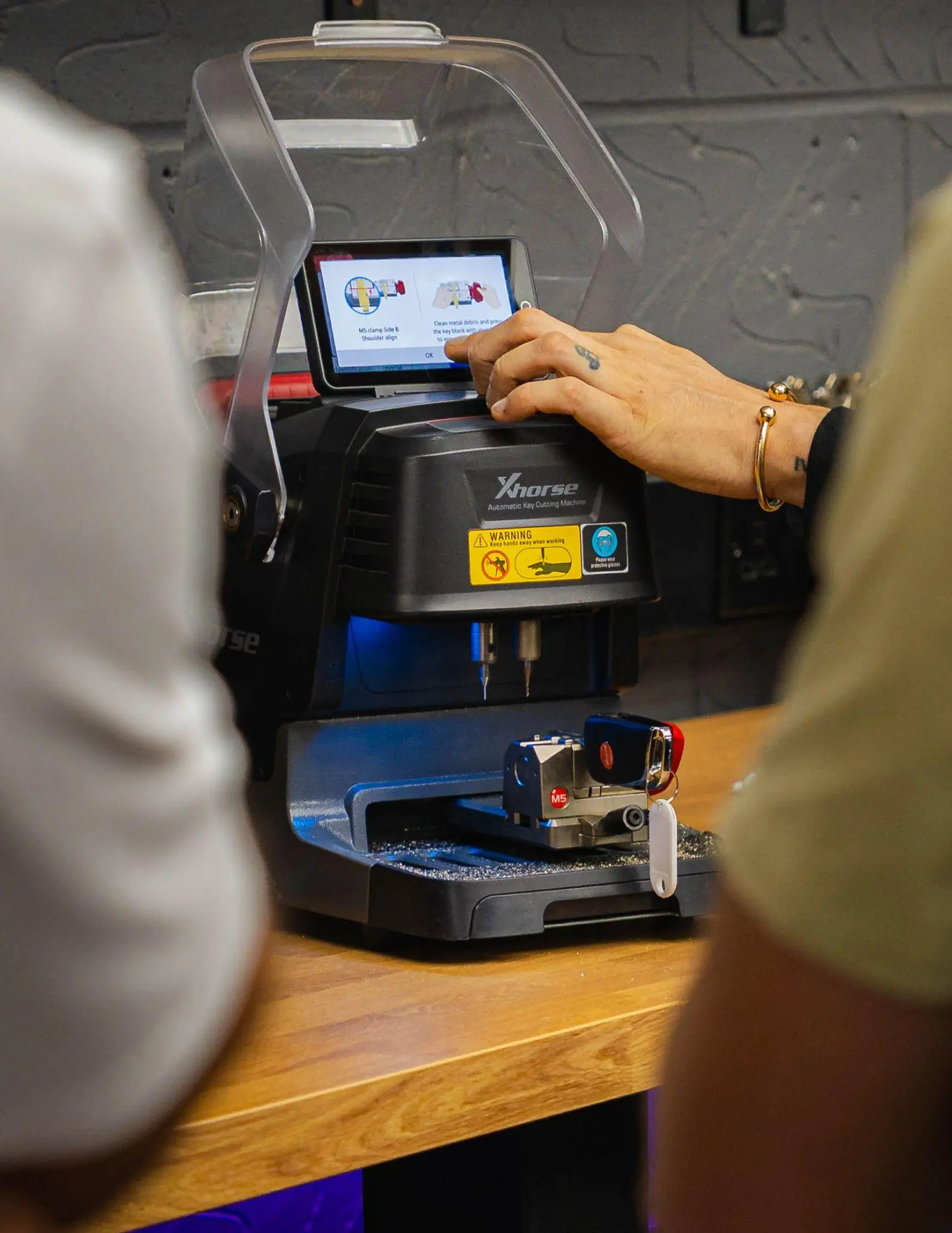 A trainee sets up a car key in an Xhorse automatic key cutting machine